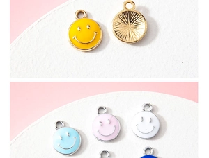 Macro shot of colorful enamel smiley face charms with golden wavy texture on the back