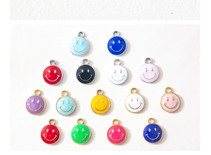 Flat lay of colorful enamel smiley face charms for DIY jewelry making and pendants