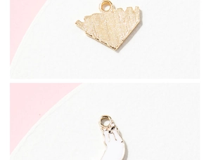 Détail macro du pendentif chat blanc montrant la texture mesh et l'émail poli