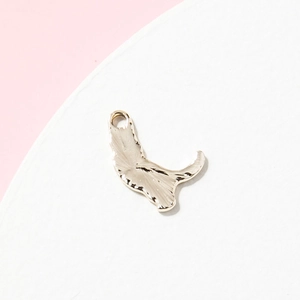 Pendentif chat doré en alliage avec texture martelée sur un présentoir blanc épuré