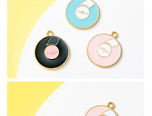 Macro view of colorful enamel record charms with WOW text and golden hanging loops