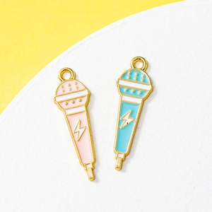 Pink and blue microphone enamel charms with golden lightning patterns on yellow background