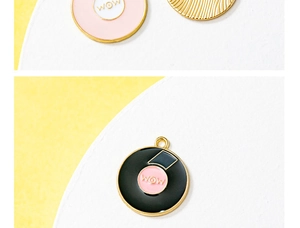 Macro view of round enamel WOW charms with gold plating and vinyl record texture