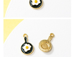 Close-up of alloy enamel frying pan with fried egg charm for jewelry making