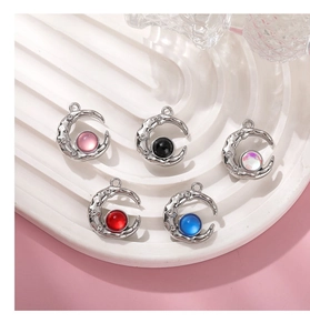 Detail of five colorful moon pendants with rhinestones on a decorative white tray