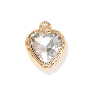 Golden heart pendant featuring a faceted clear crystal and decorative wave texture border
