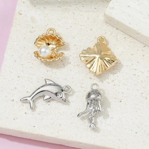 Colgantes de joyas marinas con perlas de concha doradas y medusas delfín de plata