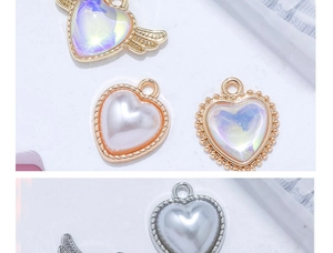 Makroaufnahme von Herzanhängern aus Perlen in Gold- und Silberrahmen für DIY-Schmuck