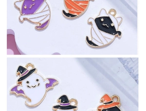 Macro detail van Halloween emaille bedeltjes met spook en mummie kat met paarse hoed