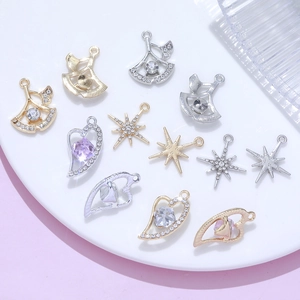 DIY ginkgo leaf and heart pendants with zircon stones on white ceramic plate