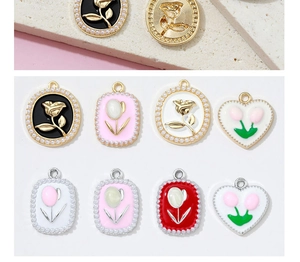 Detailed macro of vintage flower alloy charms with pearl borders and enamel finish