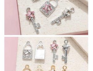 Detailed view of key and lock pendants with pink crystal stars and rhinestones
