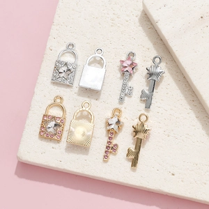Exquisite key and lock pendant set with pink rhinestones on textured stone surface