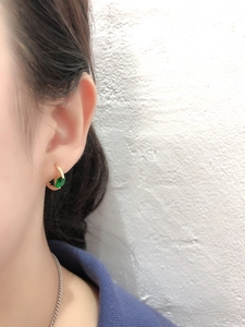 Dettaglio orecchino a cerchio in argento S925 con zircone verde sul lobo