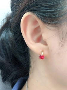 Dettaglio di un orecchino in argento s925 con pendente in zircone rosso indossato