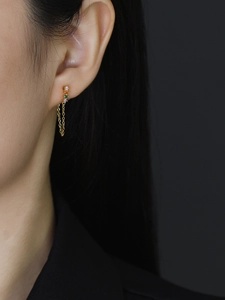 Detail of s925 silver tassel earrings with rainbow cubic zirconia on a model ear