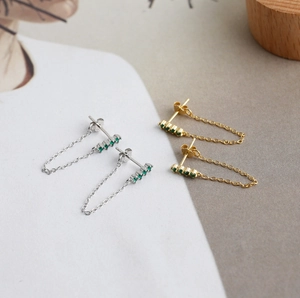 Close-up of S925 sterling silver tassel chain earrings with green zircon stones