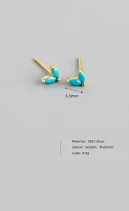 Detail shot of leaf-shaped turquoise stones set in S925 silver golden earrings