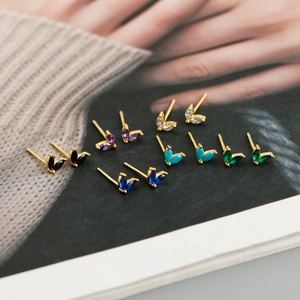 Detailed macro view of colorful marquise-cut zircon stud earrings on a magazine