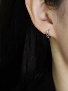 Detail shot of silver S925 sterling silver hoop earrings with textured leaf pattern design