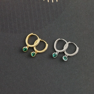 Gros plan de boucles d'oreilles en argent S925 avec pierres vert émeraude et zircons blancs