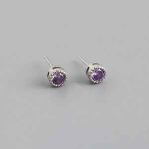Détail macro de boucles d'oreilles en argent S925 avec zircon violet rond et sertissage