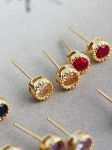 Vue macro de boucles d'oreilles en argent s925 avec zircons colorés et bordure perlée