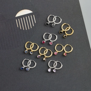 Gros plan de boucles d'oreilles en argent 925 avec pierres colorées et diamants pavés fins
