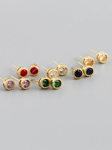 Gros plan de boucles d'oreilles en zircon coloré avec montures dorées grainées