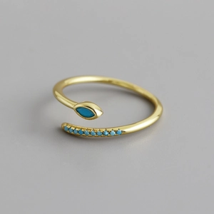 Macro shot of gold snake ring with marquise blue zircon and adjustable band detail