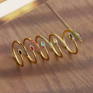 Macro shot of five adjustable gold-plated rings with colorful marquise-shaped zircons