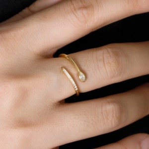 Elegant gold bypass ring with marquise-cut crystal and pavé diamonds worn on finger