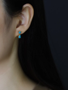 Macro shot of 925 sterling silver drop earrings with light blue pear-cut zircon stones