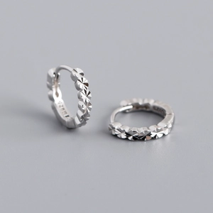 Macro detail of S925 sterling silver hoop earrings with faceted diamond-cut texture