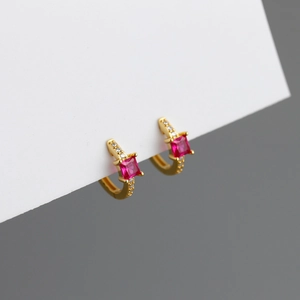 Detail van gouden oorringen met vierkante roze zirkoon en witte micro-pave details