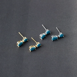 Detail of silver and gold teardrop turquoise stud earrings with claw setting