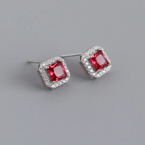 Detail of square halo stud earrings with a red center stone and silver base