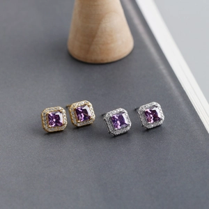 Detailed macro view of square purple zircon earrings with halo stones in gold and silver