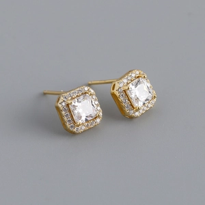 Macro view of square princess cut zircon earrings with gold plating and paved stones