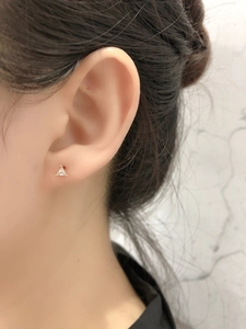 Gros plan de boucles d'oreilles triangles dorées minimalistes avec zircon clair