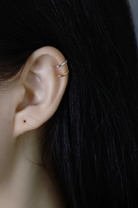 Close-up of minimalist gold and silver S925 sterling silver ear cuffs on model