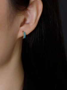 Detailed close-up of S925 silver hoop earring with rectangular turquoise stones on ear