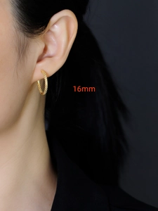 Macro zijaanzicht van 16mm gouden oorringen met kaviaar textuur op een model