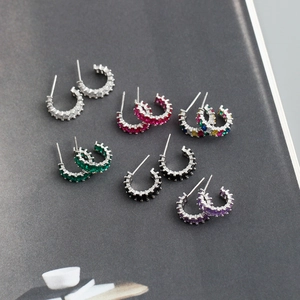 Detailed view of six pairs of sterling silver earrings with colorful square zircons