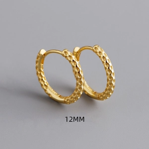 Detail van 12mm gouden oorringen met een honingraatpatroon en handige scharniersluiting