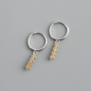 Détail de créoles en argent 925 avec une rangée de quatre pierres de zircon jaunes