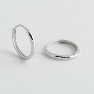 Dettaglio degli orecchini a cerchio in argento sterling S925 con marchio visibile