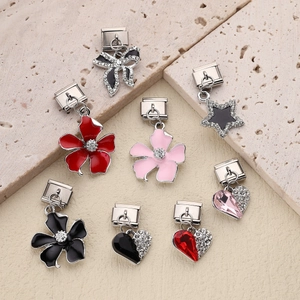 Italian charm bracelet links featuring enamel flowers and heart pendants on stone