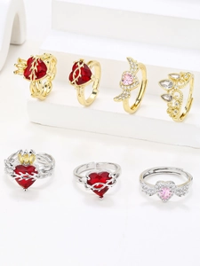 Macro shot of wing-shaped rings with red and pink heart stones on a white tier
