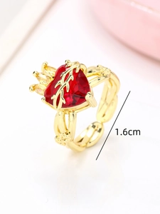 Detail showing 1.6cm diameter measurement of a gold heart ring with red gemstone